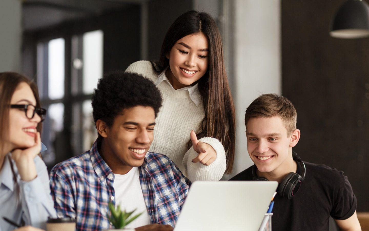 étudiants qui regardent l'ordinateur en souriant